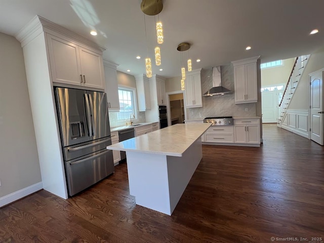 44 Primrose Ln, Cromwell, CT 06416 - kitchen featuring wall chimney exhaust hood, appliances with stainless steel finishes, backsplash, dark wood-style flooring, and a center island