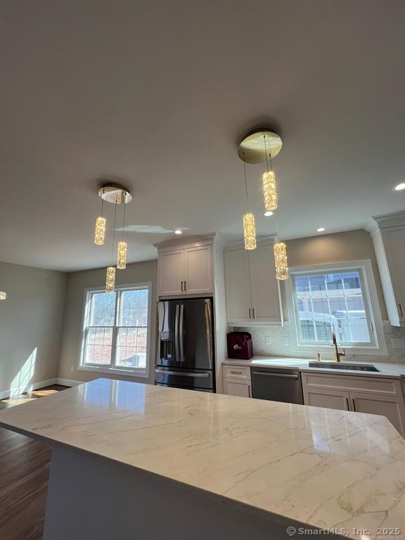 44 Primrose Ln, Cromwell, CT 06416 - kitchen with refrigerator with ice dispenser, tasteful backsplash, light stone counters, stainless steel dishwasher, and hanging light fixtures