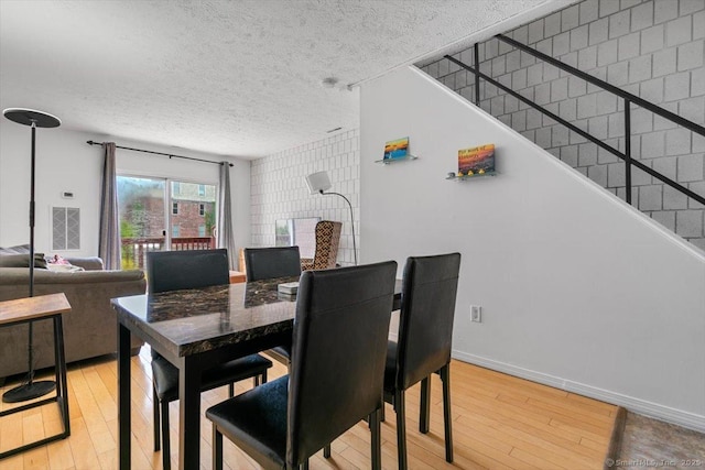 125 Olive St Apt D2, New Haven, CT 06511 - dining room featuring light wood-style flooring, a textured ceiling, and stairway
