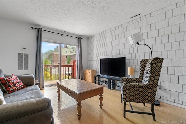 125 Olive St Apt D2, New Haven, CT 06511 - living room with wood finished floors, a textured ceiling, and tile walls