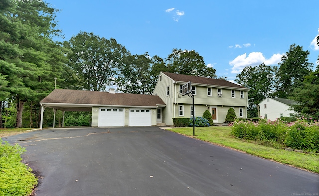 186 Wood Pond Rd, South Windsor, CT 06074 - colonial-style house featuring a garage, asphalt driveway, a carport, and a front yard
