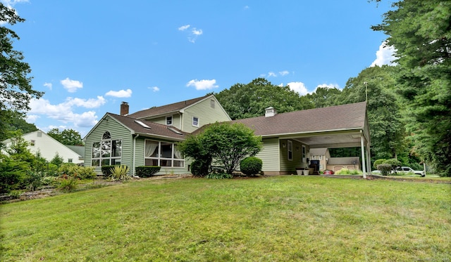186 Wood Pond Rd, South Windsor, CT 06074 - rear view of property featuring a lawn, a chimney, a sunroom, and an attached carport