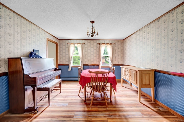 186 Wood Pond Rd, South Windsor, CT 06074 - dining room featuring baseboard heating, light wood-style floors, ornamental molding, a textured ceiling, and wallpapered walls