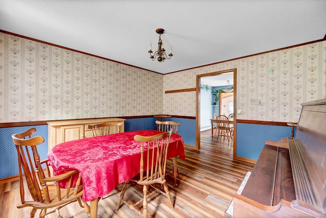 186 Wood Pond Rd, South Windsor, CT 06074 - dining area with wood finished floors, wainscoting, crown molding, a chandelier, and wallpapered walls