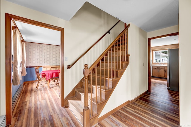 186 Wood Pond Rd, South Windsor, CT 06074 - stairs featuring wallpapered walls, wood finished floors, and a baseboard radiator