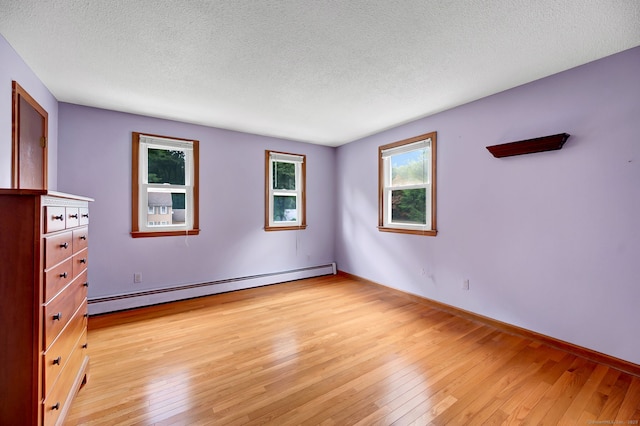 186 Wood Pond Rd, South Windsor, CT 06074 - unfurnished bedroom featuring baseboard heating, light wood-type flooring, and a textured ceiling
