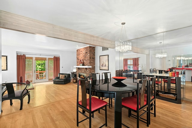 376 Woodridge Unit 376, Shelton, CT 06484 - dining space featuring light wood-style flooring, a chandelier, and a fireplace