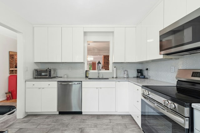 376 Woodridge Unit 376, Shelton, CT 06484 - kitchen featuring stainless steel appliances, light countertops, backsplash, and white cabinetry