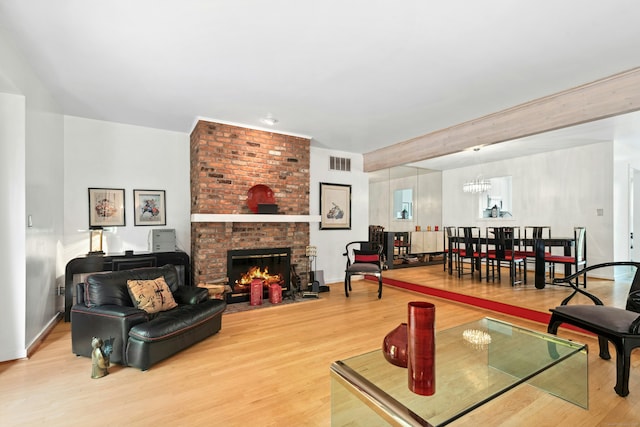 376 Woodridge Unit 376, Shelton, CT 06484 - living room featuring light wood finished floors, a fireplace, and a chandelier