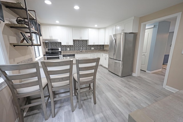 44 Hitching Post Ln Unit 44, Glastonbury, CT 06033 - kitchen with appliances with stainless steel finishes, open shelves, a peninsula, under cabinet range hood, and white cabinetry