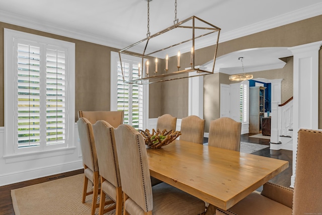 8 Jacob Ln, Killingworth, CT 06419 - dining space with a chandelier, a decorative wall, ornamental molding, dark wood-style floors, and ornate columns