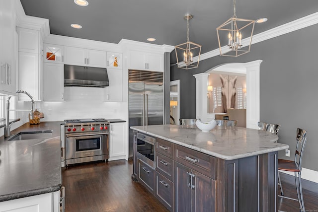 8 Jacob Ln, Killingworth, CT 06419 - kitchen featuring high end appliances, under cabinet range hood, decorative columns, white cabinets, and recessed lighting