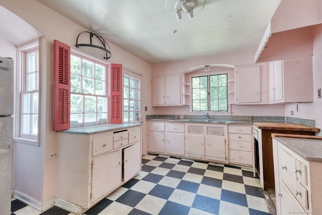 43 Buckfield Ln, Greenwich, CT 06831 - kitchen with light floors, stainless steel counters, open shelves, white cabinetry, and arched walkways
