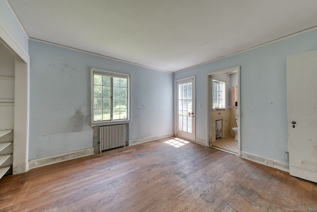 43 Buckfield Ln, Greenwich, CT 06831 - unfurnished bedroom with radiator heating unit, wood finished floors, crown molding, and connected bathroom