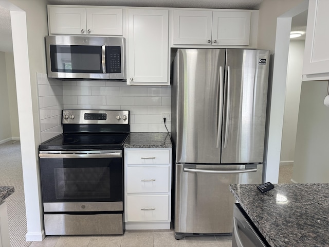 93 Trolley Crossing Ln Unit 93, Middletown, CT 06457 - kitchen featuring appliances with stainless steel finishes, dark stone counters, white cabinets, decorative backsplash, and light tile patterned floors