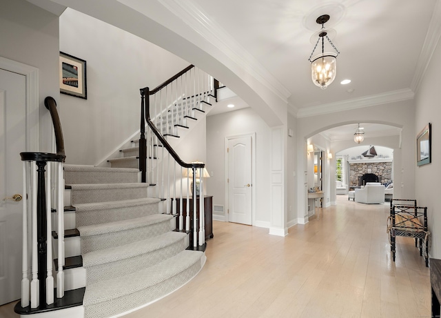 7 Merlins Ln, Newtown, CT 06470 - foyer entrance featuring arched walkways, stairs, wood finished floors, a chandelier, and crown molding