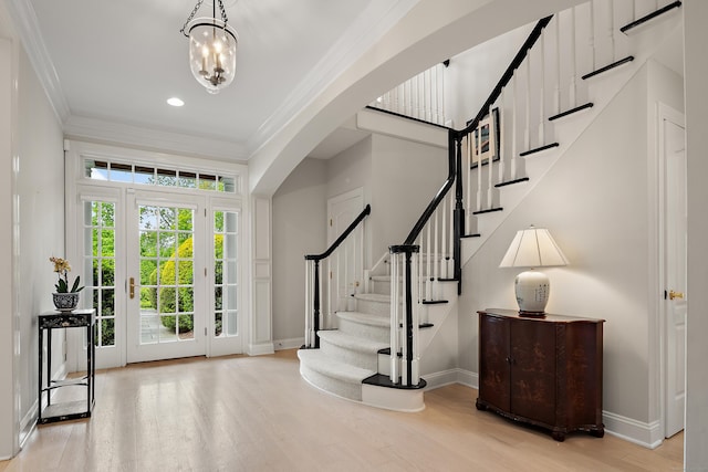 7 Merlins Ln, Newtown, CT 06470 - foyer entrance featuring ornamental molding, wood finished floors, arched walkways, stairs, and a chandelier