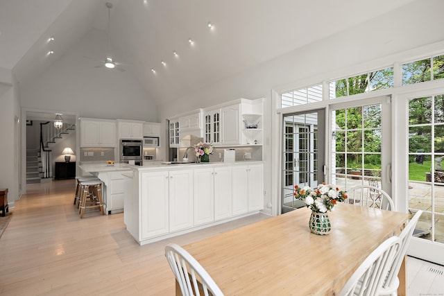 7 Merlins Ln, Newtown, CT 06470 - dining space featuring high vaulted ceiling, healthy amount of natural light, stairs, a ceiling fan, and light wood-type flooring