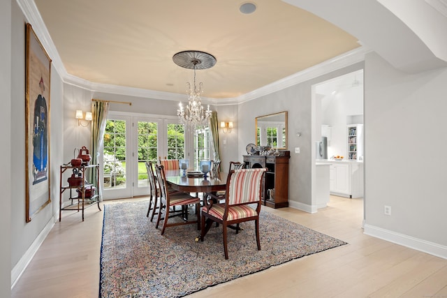 7 Merlins Ln, Newtown, CT 06470 - dining space featuring a chandelier, plenty of natural light, light wood-type flooring, ornamental molding, and arched walkways