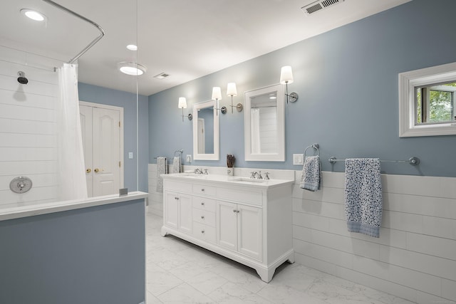7 Merlins Ln, Newtown, CT 06470 - full bath featuring marble look tile flooring, double vanity, a shower with curtain, recessed lighting, and a wainscoted wall