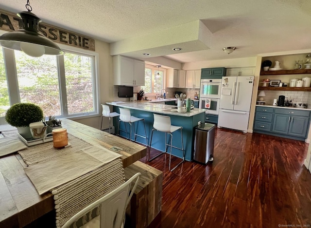 25 Hidden Pl, Cheshire, CT 06410 - kitchen with white appliances, tasteful backsplash, dark wood-style floors, a peninsula, and light countertops