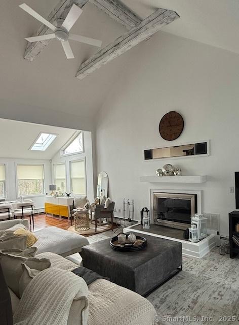 25 Hidden Pl, Cheshire, CT 06410 - living area featuring high vaulted ceiling, a glass covered fireplace, a skylight, beam ceiling, and a ceiling fan