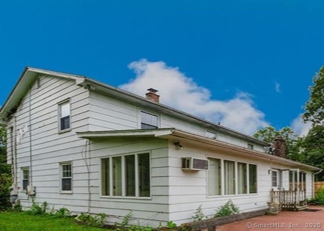 2 Rolf Dr, Danbury, CT 06810 - view of home's exterior featuring a chimney, a wall unit AC, and a yard