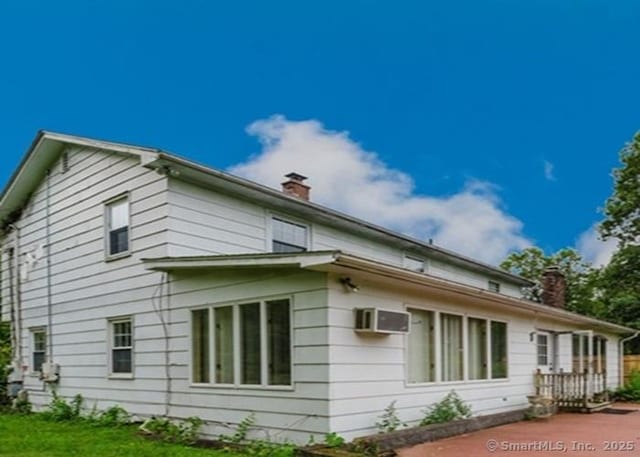 2 Rolf Dr, Danbury, CT 06810 - view of side of home featuring a chimney, an AC wall unit, and a yard
