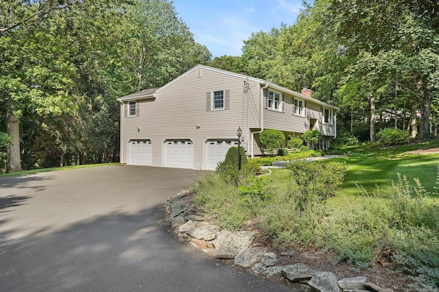 6 Robert Frost Dr, Shelton, CT 06484 - view of side of property featuring a chimney, an attached garage, asphalt driveway, and a lawn