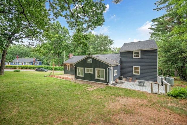 16 Pine Rd, Stafford, CT 06076 - back of house with a deck, a yard, a chimney, view of wooded area, and board and batten siding