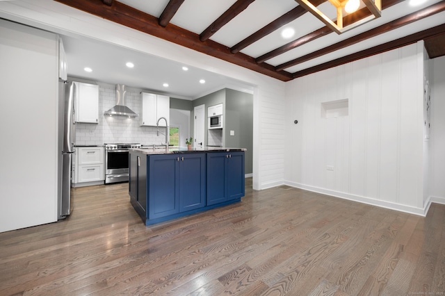 16 Pine Rd, Stafford, CT 06076 - kitchen with appliances with stainless steel finishes, wall chimney range hood, beamed ceiling, blue cabinetry, and wood finished floors