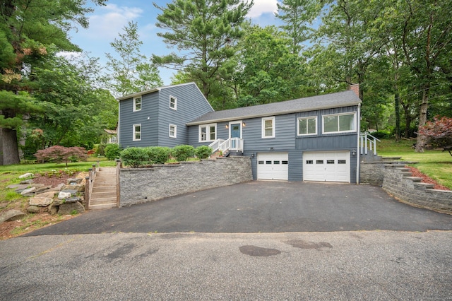 16 Pine Rd, Stafford, CT 06076 - view of front of house with stairs, a chimney, driveway, a garage, and roof with shingles