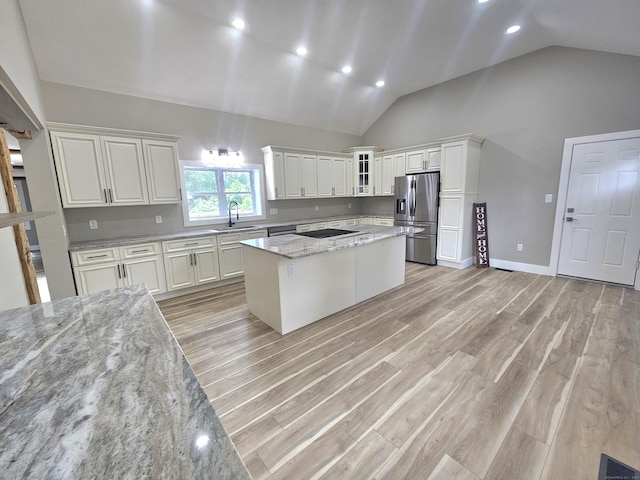 203 Old Jewett City Rd, Preston, CT 06365 - kitchen featuring stainless steel appliances, a center island, light stone countertops, light wood-type flooring, and white cabinets
