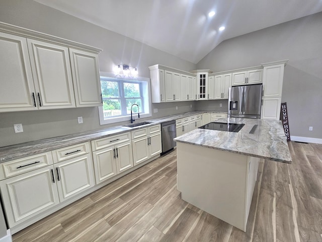 203 Old Jewett City Rd, Preston, CT 06365 - kitchen featuring appliances with stainless steel finishes, a kitchen island, lofted ceiling, light wood finished floors, and light stone counters