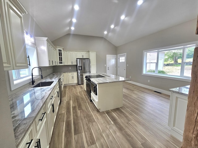 203 Old Jewett City Rd, Preston, CT 06365 - kitchen featuring stainless steel appliances, light wood finished floors, glass insert cabinets, a kitchen island, and light stone countertops