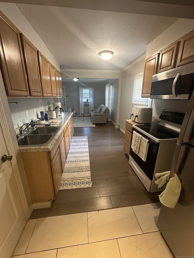 7 Suffolk Dr, East Hartford, CT 06118 - kitchen with electric range, stainless steel microwave, crown molding, plenty of natural light, and light wood-style floors