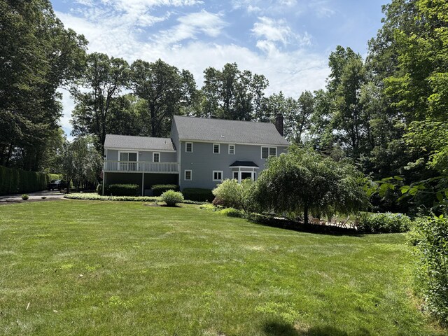 160 Cobbler Ln, Southbury, CT 06488 - back of property featuring a chimney, a lawn, and view of scattered trees