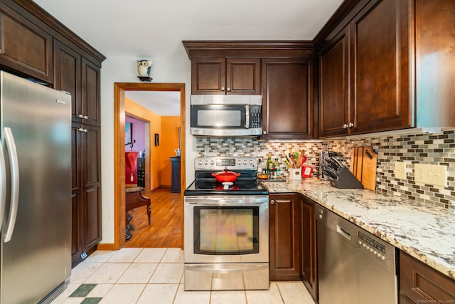 48 Greenwood Cir, Seymour, CT 06483 - kitchen with appliances with stainless steel finishes, decorative backsplash, light stone counters, and light tile patterned floors