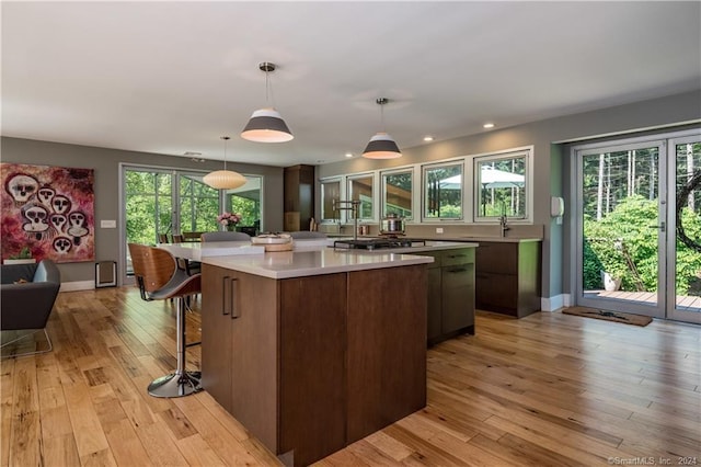 10 Firetower Rd, Killingworth, CT 06419 - kitchen featuring light countertops, a kitchen island, a breakfast bar area, light wood finished floors, and stainless steel gas cooktop