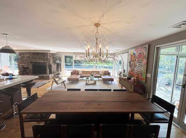 10 Firetower Rd, Killingworth, CT 06419 - dining room featuring a stone fireplace, light wood finished floors, and a chandelier