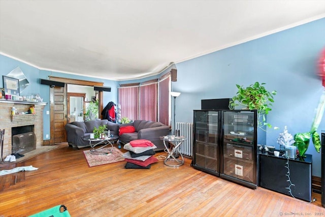212 Maple St, New Haven, CT 06511 - living room with radiator, wood finished floors, a brick fireplace, and ornamental molding