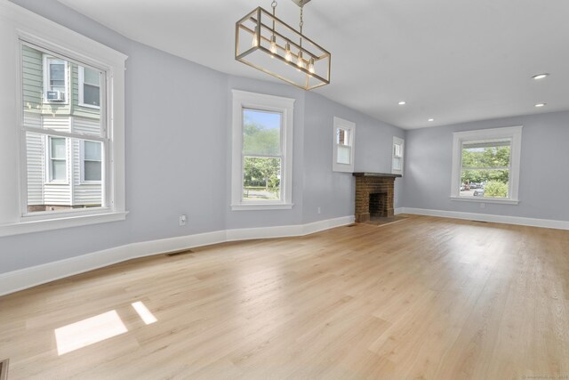 476 Washington Ave, West Haven, CT 06516 - unfurnished living room featuring healthy amount of natural light, a fireplace, light wood-style floors, a chandelier, and recessed lighting