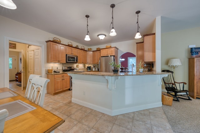 2 Warren Gln, Burlington, CT 06013 - kitchen with stainless steel appliances, a peninsula, light stone counters, a kitchen bar, and hanging light fixtures