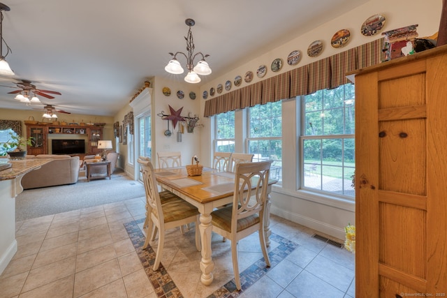 2 Warren Gln, Burlington, CT 06013 - dining room with light tile patterned flooring, ceiling fan, a chandelier, a fireplace, and light carpet