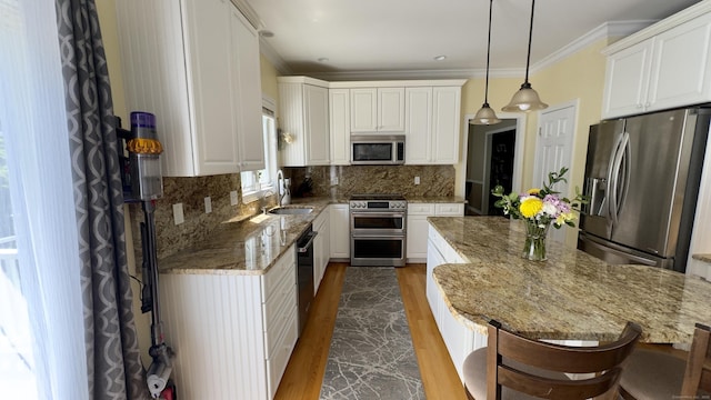 355 Oregon Rd, Cheshire, CT 06410 - kitchen featuring appliances with stainless steel finishes, dark wood-type flooring, light stone countertops, ornamental molding, and white cabinetry