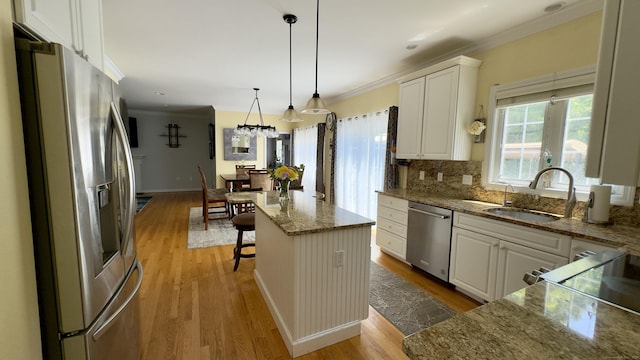 355 Oregon Rd, Cheshire, CT 06410 - kitchen with appliances with stainless steel finishes, crown molding, light wood-style flooring, white cabinetry, and a center island