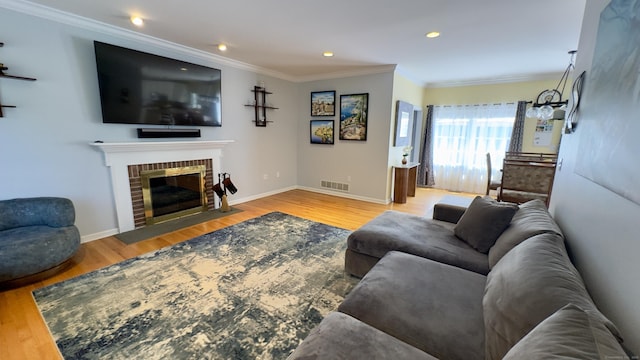 355 Oregon Rd, Cheshire, CT 06410 - living room featuring ornamental molding, wood finished floors, recessed lighting, and a brick fireplace