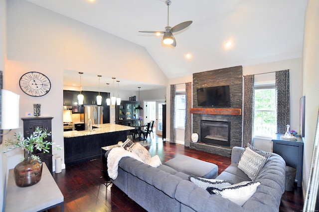 419 Briarwood Dr, Manchester, CT 06040 - living area with dark wood-type flooring, ceiling fan, high vaulted ceiling, and a stone fireplace