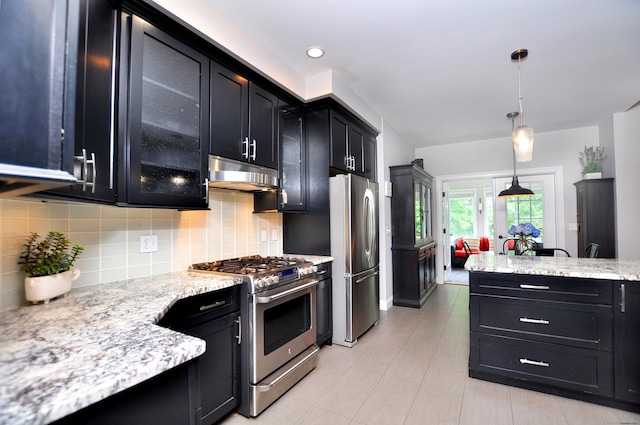 419 Briarwood Dr, Manchester, CT 06040 - kitchen featuring appliances with stainless steel finishes, dark cabinets, under cabinet range hood, tasteful backsplash, and decorative light fixtures