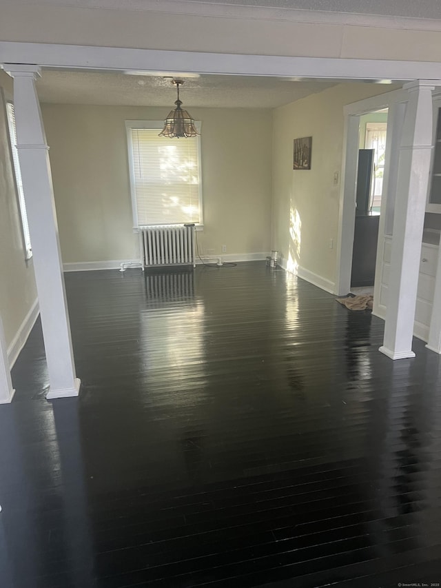24 Daniel St, East Hartford, CT 06108 - empty room with dark wood finished floors, radiator, and decorative columns